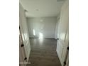 Bright bedroom with wood-look floors, white walls, and an entry featuring double doors at 17422 W Las Palmaritas Dr, Waddell, AZ 85355