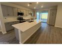 Stylish kitchen features gray cabinets, white countertops, stainless steel appliances, and large island at 17422 W Las Palmaritas Dr, Waddell, AZ 85355