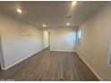 Spacious living room with wood-look floors, recessed lighting, and a neutral color palette at 17422 W Las Palmaritas Dr, Waddell, AZ 85355