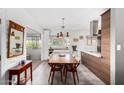 Dining area with wood table and chairs, modern lighting fixture and access to the kitchen at 1901 E Missouri Ave # 207, Phoenix, AZ 85016