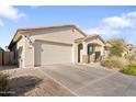 Inviting home with a two-car garage, covered porch, and desert landscaping for low maintenance appeal at 20408 E Rosa Rd, Queen Creek, AZ 85142