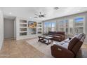 Bright living room with neutral tones, tile flooring, a ceiling fan, and built-in shelving at 2129 E Leo Pl, Chandler, AZ 85249