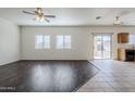 Open-concept living room with wood floors, large windows, and sliding glass door at 2220 N 91St Gln, Phoenix, AZ 85037