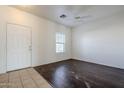 Bright living room featuring wood floors, white walls, and a ceiling fan at 2220 N 91St Gln, Phoenix, AZ 85037