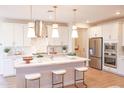 Modern kitchen with white cabinets, stainless steel appliances, a central island with bar seating, and pendant lights at 2458 W Rowel Rd, Phoenix, AZ 85085