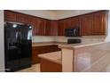 Well-equipped kitchen featuring rich wood cabinetry and modern appliances, including a refrigerator and microwave at 25564 W Magnolia St, Buckeye, AZ 85326