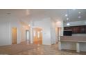 Bright, open living room with neutral tile flooring leading to a dining area at 25564 W Magnolia St, Buckeye, AZ 85326