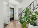 Inviting foyer with stone floors, an elegant staircase, and a decorative front door at 3226 E Sells Dr, Phoenix, AZ 85018
