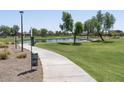 Scenic community park with a lake, walking paths, and grassy areas for recreation at 36503 W San Ildefanso Ave, Maricopa, AZ 85138
