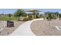 Community park featuring a playground, covered picnic area, and lush green space at 36503 W San Ildefanso Ave, Maricopa, AZ 85138