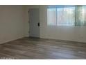 Bright living room features wood-look flooring and natural light from a large window at 5518 E Lindstrom Ln # B3, Mesa, AZ 85215