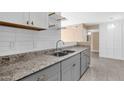 Kitchen sink featuring stainless steel fixtures, light countertops, and white shelving at 623 W Guadalupe Rd # 131, Mesa, AZ 85210