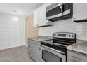 Modern kitchen featuring stainless steel appliances, light countertops, and stylish gray and white cabinetry at 623 W Guadalupe Rd # 131, Mesa, AZ 85210