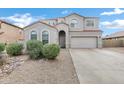 A charming two-story home with a red tile roof, stucco exterior, arched windows, desert landscaping and an attached two-car garage at 647 E Palomino Way, San Tan Valley, AZ 85143