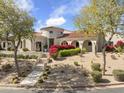Well-maintained home with desert landscaping, mature trees, and a red-tiled roof at 19494 N 98Th Pl, Scottsdale, AZ 85255