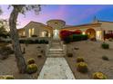 Stunning home featuring a neutral color scheme, desert landscaping, and red flowering bushes at 19494 N 98Th Pl, Scottsdale, AZ 85255