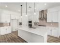 Bright kitchen with a spacious island, modern appliances, and stylish pendant lighting at 20624 S 216Th Pl, Queen Creek, AZ 85142