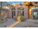 Landscaped front entrance with desert plants, arched windows, and decorative front door at 29423 N 145Th Pl, Scottsdale, AZ 85262