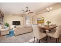 Open-concept living room featuring neutral furniture, a ceiling fan, and a dining area with seating for six at 4102 E Cathedral Rock Dr, Phoenix, AZ 85044