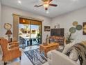 Cozy living room with wicker furniture, ceiling fan, and sliding glass doors to the patio at 4241 N Pebble Creek Pkwy # 42, Goodyear, AZ 85395