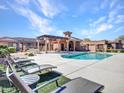 Community pool surrounded by lounge chairs, offering a relaxing outdoor space at 4241 N Pebble Creek Pkwy # 42, Goodyear, AZ 85395