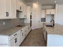 Bright kitchen with white cabinetry, granite countertops, and stainless steel appliances at 10027 W Verde Ln, Avondale, AZ 85392