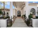 Elegant covered front entryway with an iron gate and door at 10541 E Windrose Dr, Scottsdale, AZ 85259
