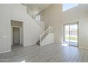 Bright, open-concept living area with a staircase, tile floors, and access to the backyard at 1236 E Mescal St, Phoenix, AZ 85020