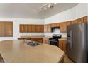 Functional kitchen featuring wood cabinets, stainless steel appliances, and a breakfast bar at 14994 W Charter Oak Rd, Surprise, AZ 85379