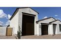 Side view of a home showcasing the stucco exterior and a large three-car garage at 15782 W Cheryl Dr, Waddell, AZ 85355