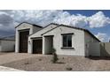 A bright stucco home featuring a three-car garage, desert landscaping, and a crisp, modern aesthetic at 15782 W Cheryl Dr, Waddell, AZ 85355