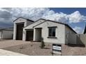 New build with stucco, brown accents, and a three-car garage with landscaping at 15782 W Cheryl Dr, Waddell, AZ 85355