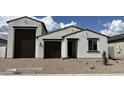 Charming single-story home with a stucco exterior, brown accents, and a three-car garage at 15782 W Cheryl Dr, Waddell, AZ 85355