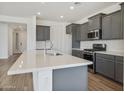 A contemporary kitchen with gray cabinets, a stainless steel microwave, and white countertops on an island at 17300 W Dahlia Dr, Surprise, AZ 85388