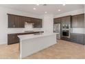 Open kitchen features stainless steel appliances, a center island, and dark wood cabinetry at 17347 W Chama Dr, Surprise, AZ 85387