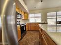 Well-lit kitchen with stainless steel appliances, wood cabinetry, and quartz countertops at 1771 E Erie St, Gilbert, AZ 85295