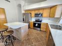 Spacious kitchen with an island, stainless steel appliances, and wood cabinets for ample storage at 1771 E Erie St, Gilbert, AZ 85295