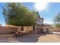 Backyard view features neutral color tones and a spacious gravel area with a tree in the yard at 25589 W Pleasant Ln, Buckeye, AZ 85326