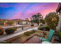 Charming street view with lush landscaping, mountain views and chair on front patio at 3226 E Lazy Ln, Phoenix, AZ 85028
