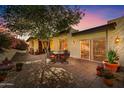 Charming patio with brick pavers, dining set, and lush landscaping for relaxing outdoors at sunset at 3500 E Lincoln Dr # 6, Phoenix, AZ 85018