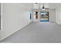 Spacious, naturally lit living room with a ceiling fan and sliding glass doors to the backyard at 40995 W Portis Dr, Maricopa, AZ 85138