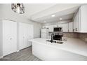 An open concept kitchen with white cabinets, stainless steel appliances, and a spacious island at 4737 E Belleview St, Phoenix, AZ 85008