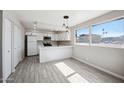 Modern kitchen with stainless steel appliances, white cabinets, and a spacious breakfast nook at 4737 E Belleview St, Phoenix, AZ 85008