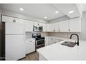 Modern kitchen with stainless steel appliances, white cabinets, and quartz countertops at 4737 E Belleview St, Phoenix, AZ 85008