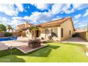 Spacious backyard featuring a pool, putting green, and shaded patio perfect for outdoor entertainment at 607 W Palo Verde St, Gilbert, AZ 85233