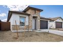 Well-maintained single-story home showcasing stone details, a garage, and simple desert landscaping at 7649 W Minton St, Laveen, AZ 85339