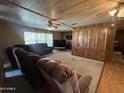 Comfortable living room with plush seating, carpeted floor, and wood-paneled walls at 8269 E Desert Trl, Mesa, AZ 85208