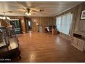 Spacious living area with wood paneling, natural light, and laminate flooring at 8269 E Desert Trl, Mesa, AZ 85208
