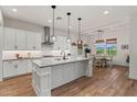 Bright kitchen boasts white cabinetry, center island, stainless hood, herringbone backsplash, & adjacent dining space at 11241 N Blakely St, Surprise, AZ 85388