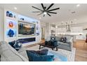 Open-concept living room that adjoins a modern kitchen with white cabinetry at 11241 N Blakely St, Surprise, AZ 85388